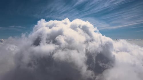 Aerial View From Airplane Window at High Altitude of Earth Covered with White Puffy Cumulus Clouds