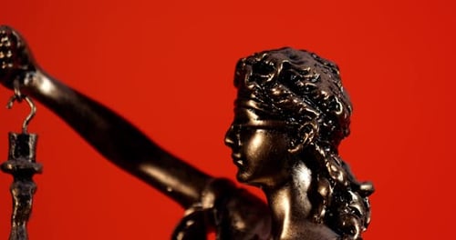 Statue of Justice extreme close up on red background