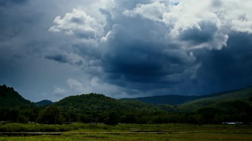Zeitraffer der Regenwolken, die sich am Himmel über den grünen Feldern bewegen