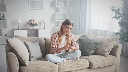 Woman Using Mobile Phone on Sofa