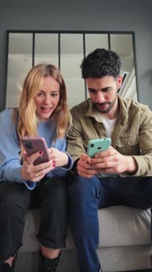 Vertical Female Holding a Credit Card Shopping Online and Her Husband Pointing Her Smart Phone Adult