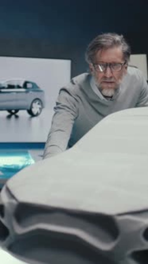 Des ingénieurs automobiles travaillent dans un studio et discutent de la conception d'un prototype de sculpture automobile