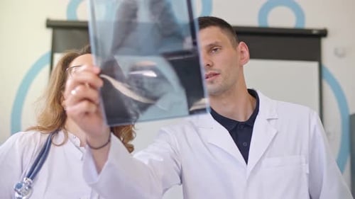 Doctors Discussing X-Ray in Medical Office