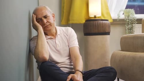 Senior Man Sitting on Floor, Sad