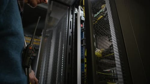 Data Center Engineer Maintaining Server Rack and Network Cables