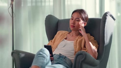 Woman Relaxing in Armchair with Mobile Phone
