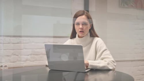 Woman Surprised While Working on Laptop at Home