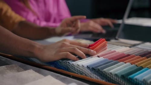 Close Up Details Woman Assistant and Man Designer Choosing Color Fabric Samples Hands Touch Textile