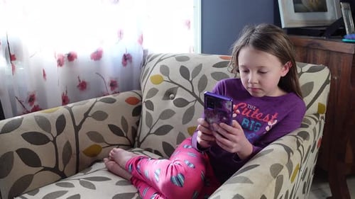 Child Using Mobile Phone While Relaxing Indoors