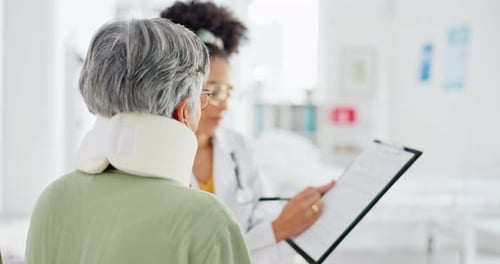 Female Doctor Consults with Patient in Hospital