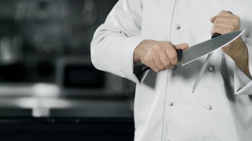 Chef Hands Sharpening Knife in . Closeup Man Hands Prepare To