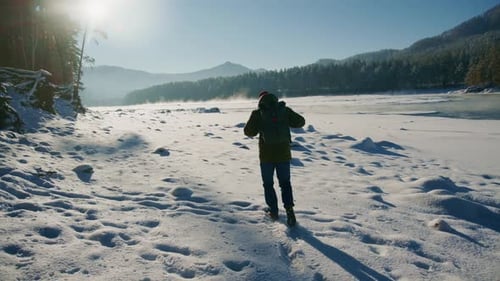 Hiker Walking Through Snowy Winter Mountain Landscape