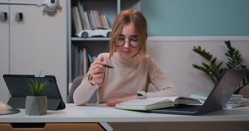 Girl Studying and Writing at Desk at Home