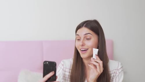 hermosa chica hablando por teléfono en las redes sociales sobre la crema para los ojos