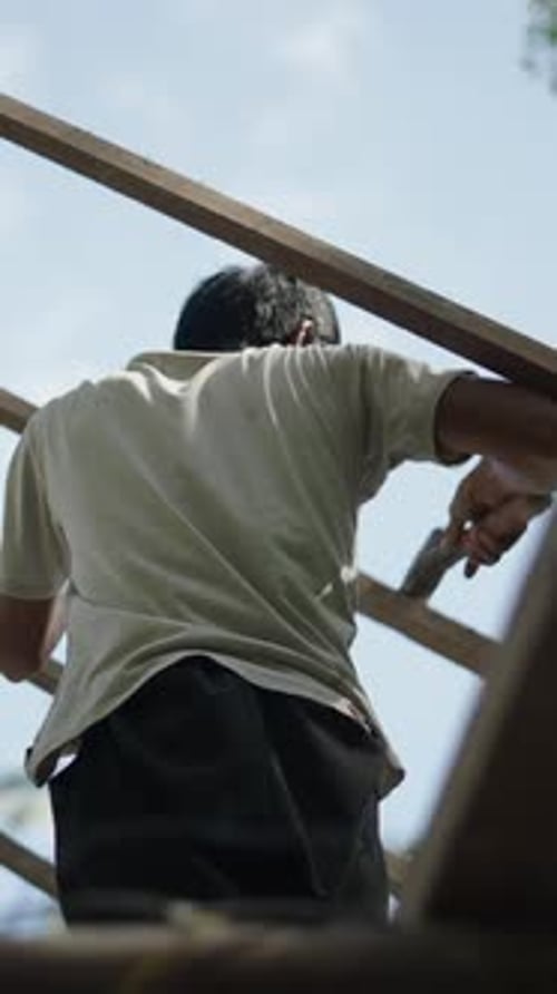 Man Working on Wood Construction Outdoors