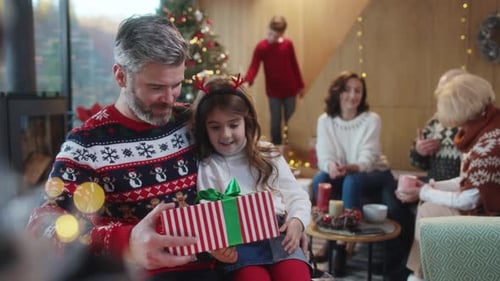 Dad and Daughter Opening Christmas Gift Together
