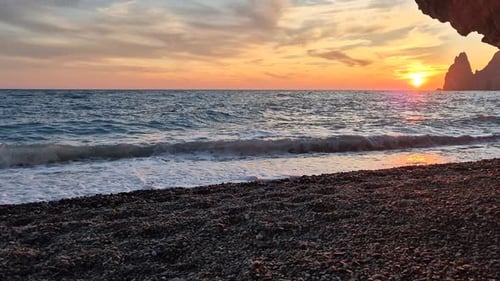 Sunset Ocean Beach Waves Lapping Pebble Shore Vibrant Sky Scenic Cliffs Tranquil Nature Travel