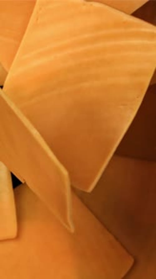 Sliced Cheddar Cheese Flies on a Black Background Filmed on a Highspeed Camera at 1000 Fps
