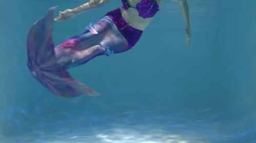 Nahaufnahme eines Meerjungfrauenschwanzes, der beim Schwimmen unter Wasser schwankt