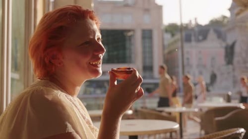 Relaxing Woman Enjoying Snack in a Sunlit Cafe in the City of Lisbon
