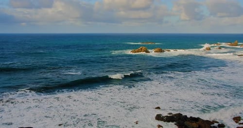 Dramatic Waves Crashing on Rocky Coastline from Above