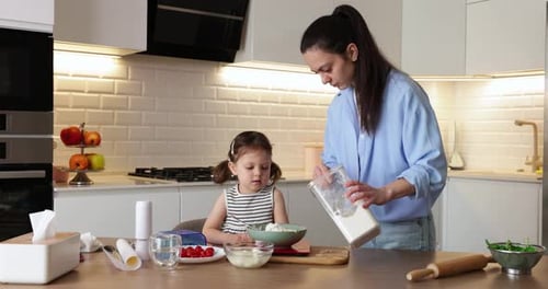 Woman and Girl Cooking Together in Kitchen