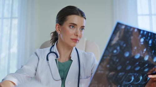 Female Doctor Examining X-ray in Hospital Office