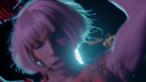 Drag Queen in a Red Dress Flaunts on Camera on the Street with Neon Lighting