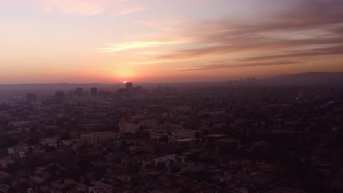 Wide aerial shot of the sun disappearing over the horizon in the city of Los Angeles. 4K