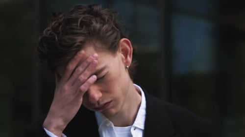 Closeup Portrait of Tired Upset Sad Young Caucasian Man Rubbing Bridge of Nose Millennial Guy