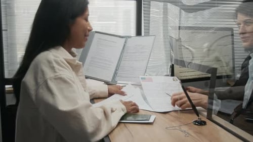 Hispanic Woman Listening to Advice from US Consulate Officer on Visa Application
