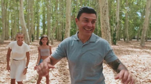 Família feliz brincando de esconde-esconde no parque, o pai está contando