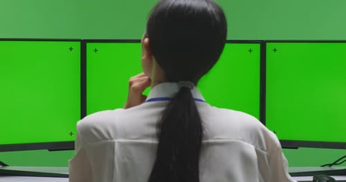 Asian Woman Thinking While Working With Mock Up Multiple Monitor In Green Screen Studio