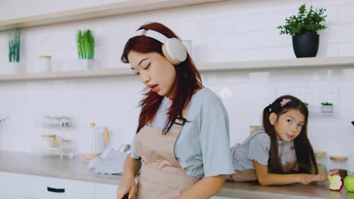 Woman Cooking in Kitchen as Child Watches