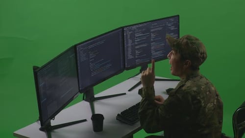 Side View Of Man Soldier Thinking While Write Code With Multiple Computer Screens In Green Screen