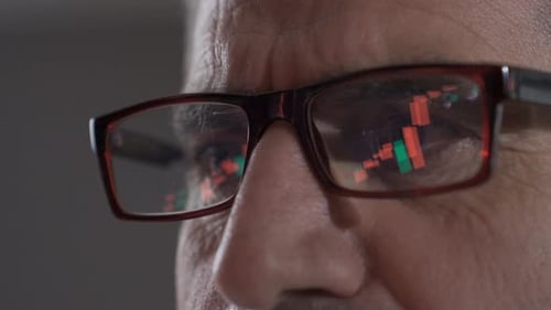 Mature trader man analyzing a stock market and cryptocurrency chart.