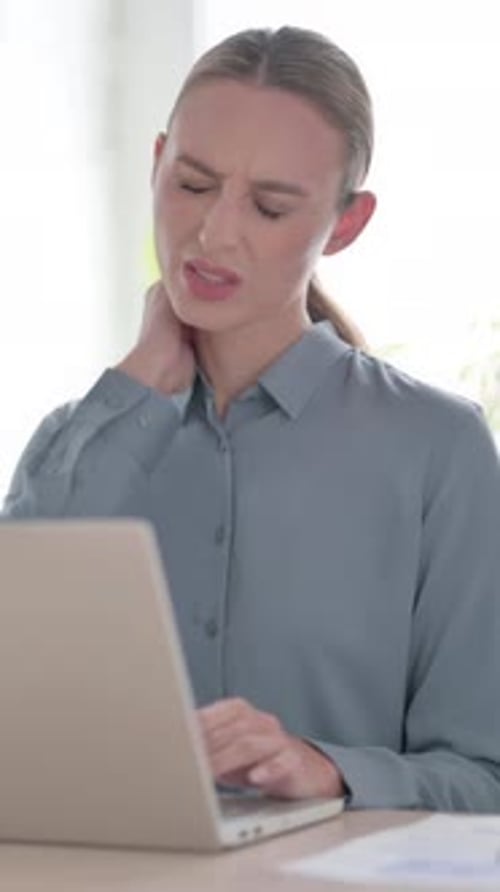 Woman having Neck Pain while using Laptop in Office, Vertical Video