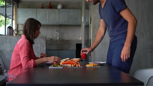 Adults eating lunch and talking in modern home