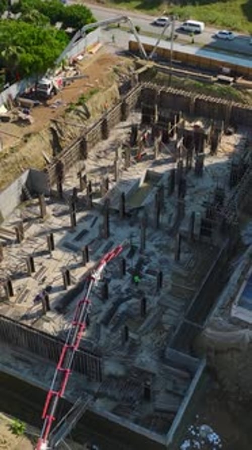 Vertical Video Engineers Guide Workers Shaping Rebar and Pouring Concrete on a HighQuality