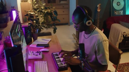 Music Producer Using MIDI Keyboard and Computer at Home Studio