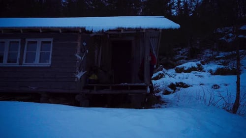 Person Arriving at a Winter Cabin with Dog