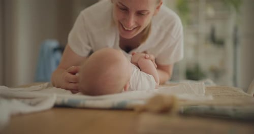 Mother lovingly plays with her newborn baby at home