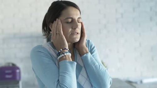 Woman Massaging Temples due to Headache Pain