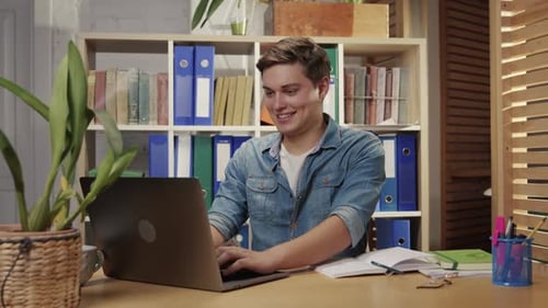Happy Man Working on Laptop, Celebrating Success with Money