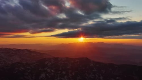 Orange Sunset Over Mountain with Dramatic Clouds