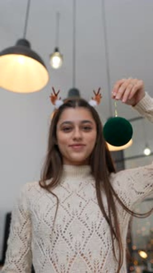 The Festive Holiday Ornament Display Complemented By a Cozy Sweater Creates a Warm Atmosphere