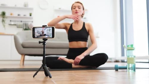 Mujer filmando un tutorial de yoga en casa
