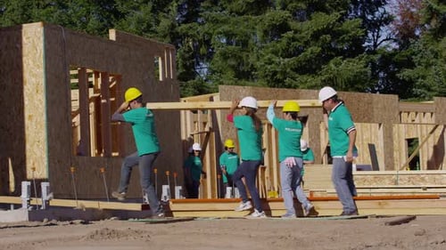 Volunteers Building a House on Construction Site