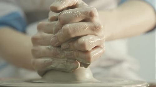 Close Up of Hands Shaping Clay on Wheel
