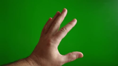 1. Mann zeigt OK-Schild mit Finger auf grünem Hintergrund